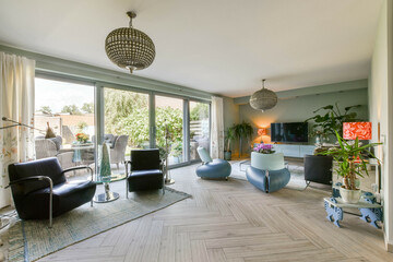 A chic living room showcasing contemporary furniture with large windows for natural light, accented by plants and decorative lamps, creating a warm and inviting atmosphere.