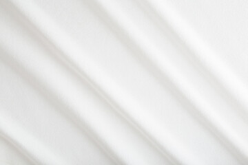 White diagonal wavy bed sheet background. Closeup.  Top down view.