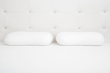 Two white soft memory foam pillows on mattress. Closeup. Front view.