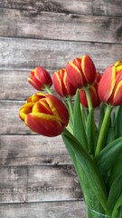 Red tulips bouquet on a wooden background.