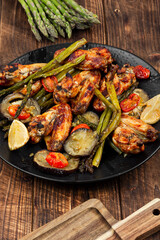 Baked chicken wings with vegetables.