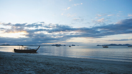 A long tail boat in the sea with a beautiful sunrise sky