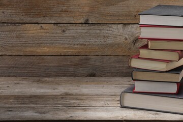 Stack of old books on wooden table, closeup. Space for text