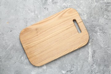 One wooden serving board on light grey textured table, top view. Space for text