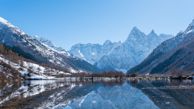 Teberda National Park. Snowy peaks of Mount Chotcha are reflected in lake as in mirror. Lake Tumanly-Gel or Tumanly-Kol (Misty Lake) is in valley of Gonachkhir River. Dombay, Karachay-Cherkessia.