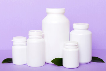 supplement pills with medicine bottle health care and medical top view. Vitamin tablets. Top view mockup bottle for pills and vitamins with green leaves, natural organic bio supplement, copy space