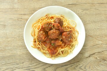 spaghetti dressing fried meatball stuffed cheese in chop onion and tomato ketchup sauce on plate  