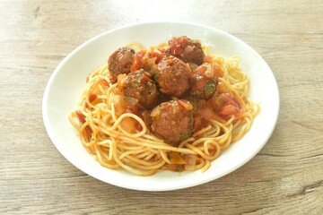 spaghetti dressing fried meatball stuffed cheese in chop onion and tomato ketchup sauce on plate  