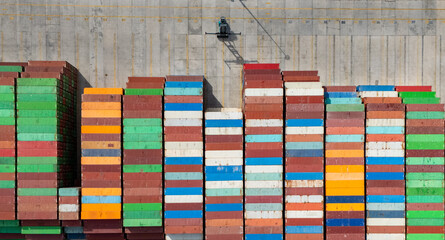 Rows of colorful shipping containers at a busy port during daylight