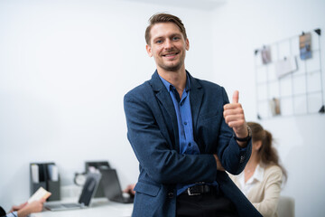 Business professional shows enthusiasm during a meeting in a modern office setting with colleagues nearby