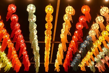 colorful paper Eastern Thai lantern style with electric lamp hanging on rooftop in night