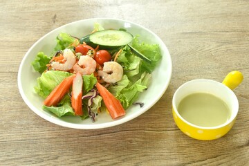 boiled shrimp and crab stick with vegetable seafood salad on plate dressing cream sauce