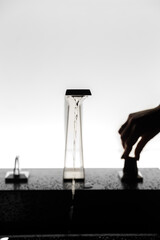 Modern chrome faucet with running water in dark bathroom, Contemporary minimalist bathroom faucet with a sleek angular design. Hand.