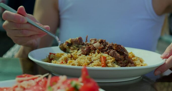 Eating Traditional Uzbek Pilaf with Fresh Salad