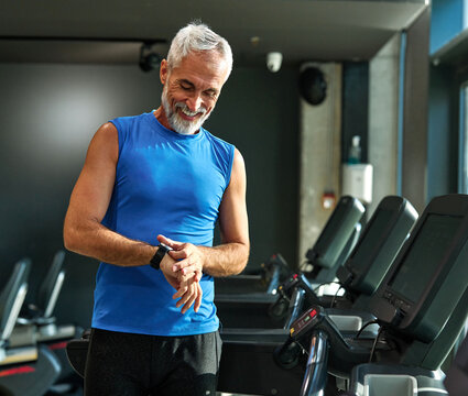 gym sport fitness exercising training mature man running watch smart time smartwatch wristwatch device app checking pulse monitor performance cardio treadmill