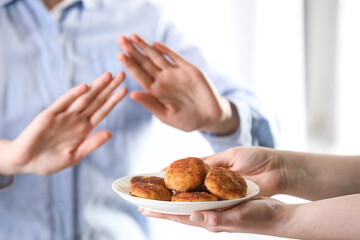Woman refusing patties indoors, selective focus. Food allergy concept