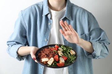 Woman refusing to eat meal on white background, closeup. Food allergy concept