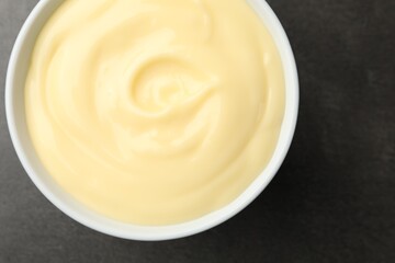 Tasty vanilla pudding on black table, top view