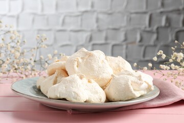 Delicious homemade meringue cookies on pink wooden table