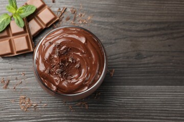 Delicious pudding in glass, chocolate and mint on wooden table, flat lay. Space for text