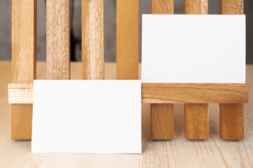 White blank business card mockup with wooden decoration on brown background