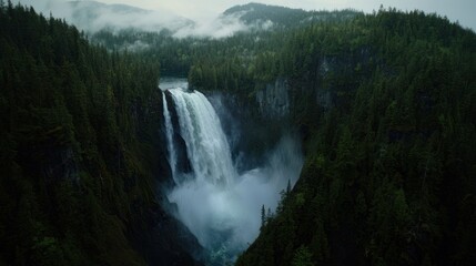 Fototapeta premium Majestic waterfall cascading into lush rainforest valley