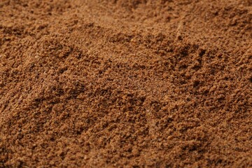 Superfood supplement. Nutmeg powder as background, closeup