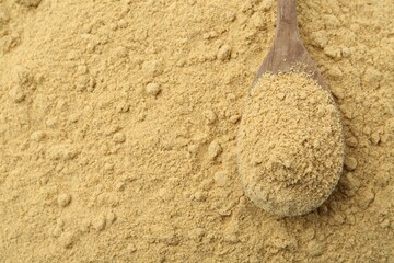 Superfood. Mustard powder and spoon as background, top view