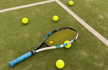 A tennis racket and new tennis ball on a tennis court