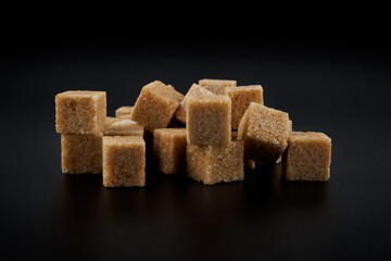 Brown sugar cubes on black background.