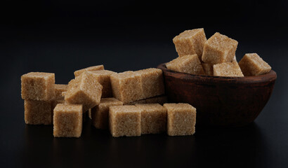 Brown sugar cubes on black background. Cane sugar.