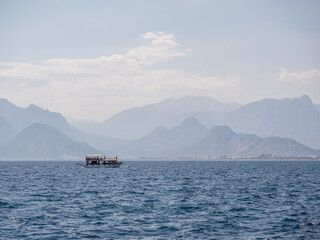 Sea and mountains in Antalya, Turkey. A magical fairy-tale landscape. A ship is sailing against the background of the mountains.