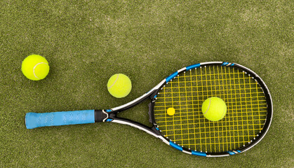 Tennis racket and ball on green background. Flat lay. Sports equipment