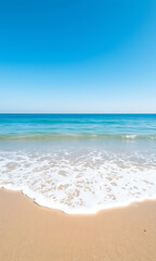 Fototapeta premium A tranquil beach scene featuring golden sand meeting gentle turquoise waves under a clear vibrant blue sky.