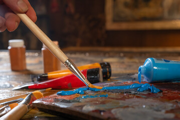 Artist s hands with brushes mixing colors