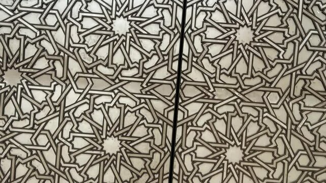 An ornate wooden door adorned with moroccan mosaic and intricate carvings reflects rich religious and artistic heritage. Delicate details and symmetrical patterns emphasize its cultural significance.