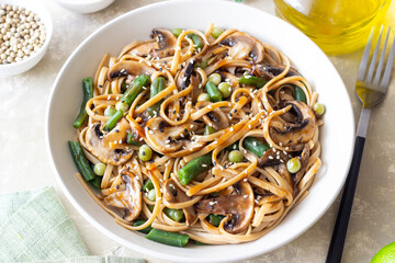 Udon noodles in teriyaki sauce with mushrooms, beans and peas. Asian cuisine. Vegetarian food.