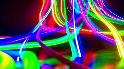 A dynamic display of vibrant neon lights artfully twists and flows, with an alluring display of brilliant colors against a dark backdrop.