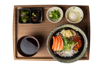 Cold soba noodles served with salmon sashimi, ikura roe, grated daikon, radish sprouts, and dipping sauce in a traditional Japanese ceramic bowl. 