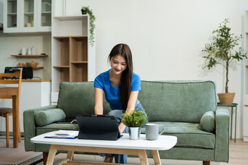 Happy woman entrepreneur working online at home office. Using a laptop for business, searching, and...