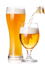 A glass of beer with a golden hue and frothy head, isolated on a clean white background