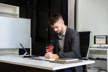 Naklejka premium Business man working at office with laptop and documents on desk, financial adviser analyzing data.