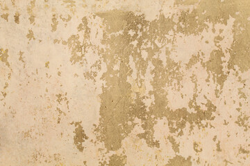 Obraz premium Cracked yellow wall paint, damaged concrete, rough texture, peeling due to changes in air temperature