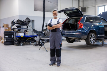 Professional technician in auto shop checking vehicle