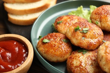 Delicious patties, parsley and ketchup on table, closeup