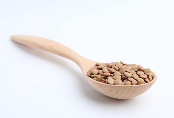 Raw lentils in wooden spoon isolated on white