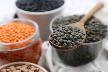 Different types of lentils on white table, closeup