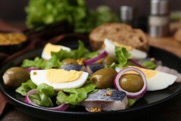 Delicious salad with herring, egg, mustard and vegetables on table, closeup