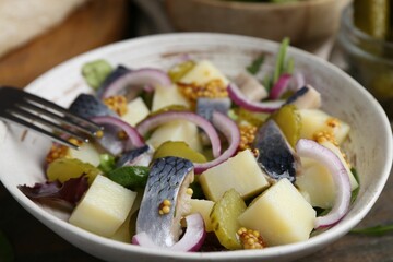 Delicious salad with herring, vegetables and mustard in bowl on table, closeup