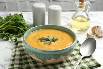 Delicious lentil cream soup with parsley served on white table